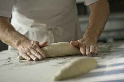 A baker kneading dough for bread